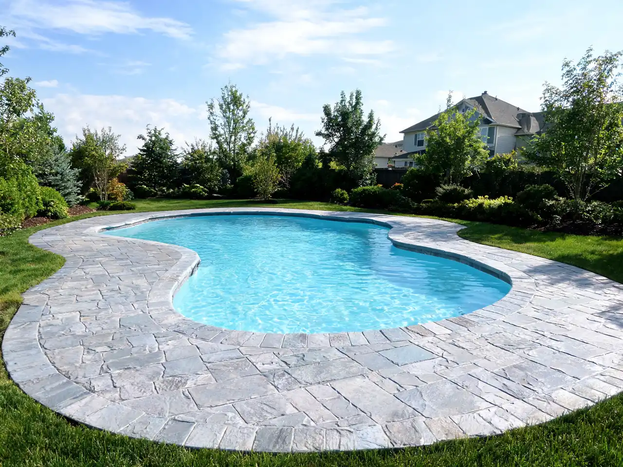Stamped concrete pool deck idea in a slate pattern around a freeform pool