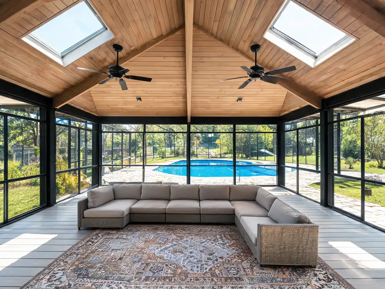 Large screened-in porch idea with vaulted wood ceiling, skylights and a sectional sofa