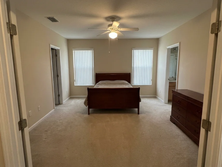Master bedroom upgraded with an upholstered headboard and layered lighting. before AI redesign