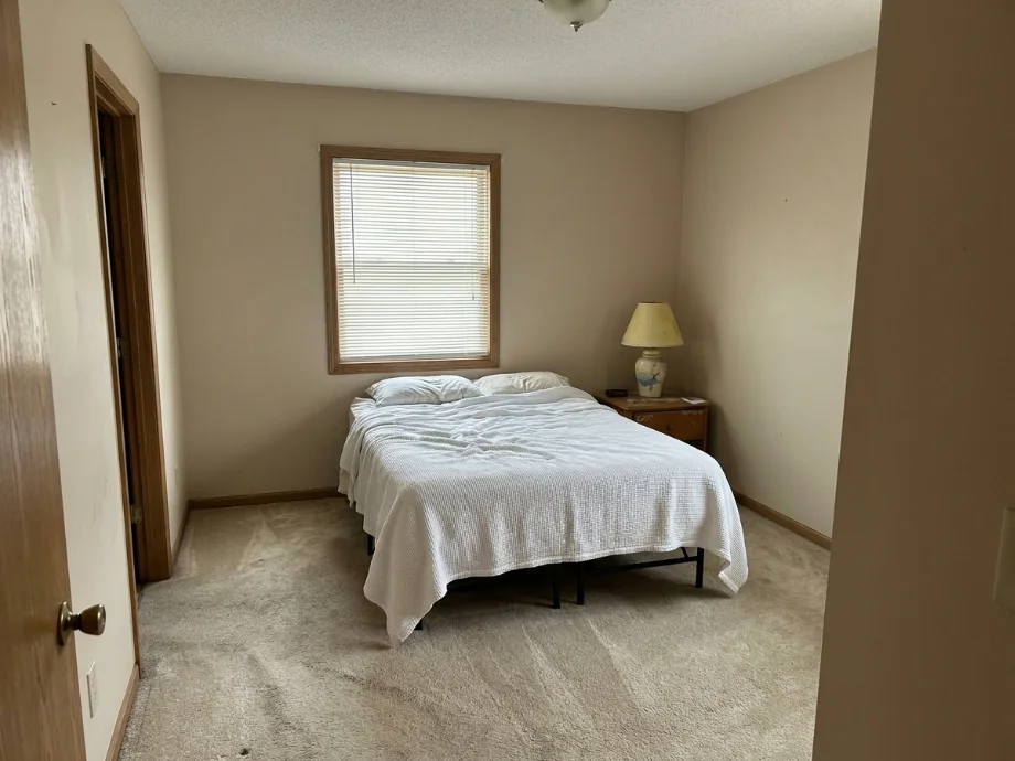Guest bedroom refreshed with a soft accent wall and built-in storage. before AI redesign