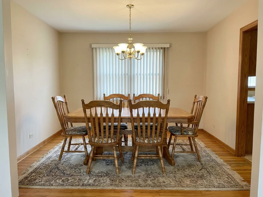 Dining room restyled with an oval table, a soft bench, and a pendant cluster. before AI redesign