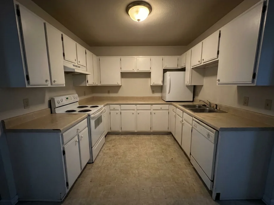 Builder-grade kitchen upgraded with quartz counters and a tile backsplash. before AI redesign