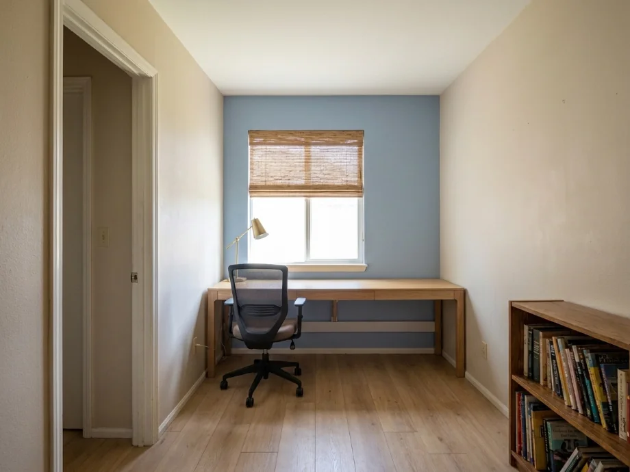 Study room restyled with a long desk, an ergonomic chair, and a task lamp. after AI redesign