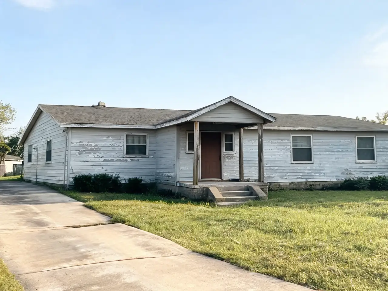AI exterior paint preview: worn gray ranch house repainted warm greige before AI redesign