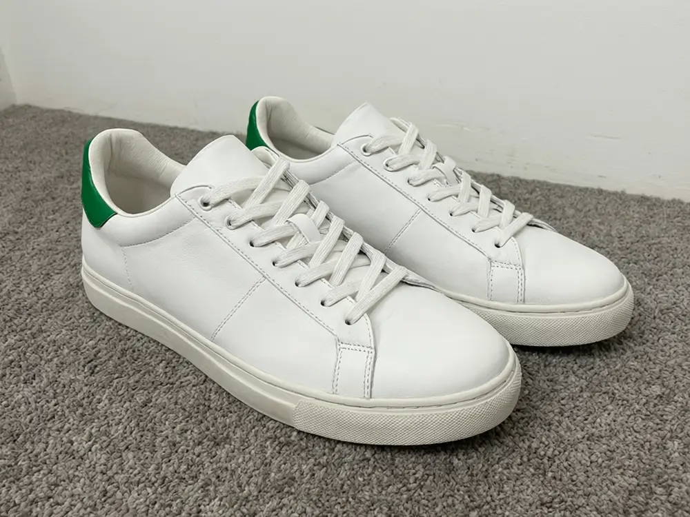 Product photo background result: white sneaker placed in a warm autumn leaf setting before AI redesign