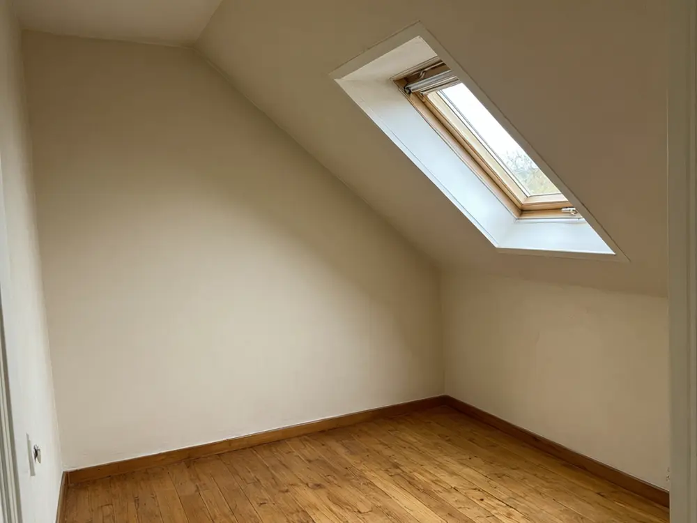 Attic conversion visualizer result: an attic home office with a wooden desk under the window before AI redesign