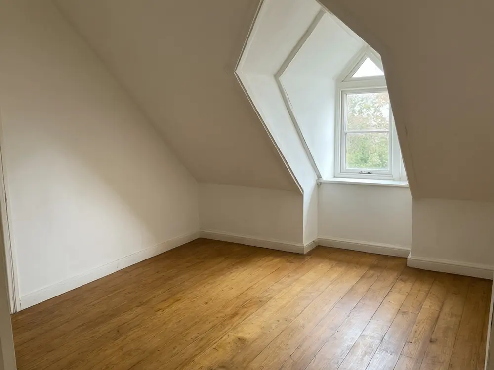 Attic conversion visualizer result: an attic playroom with soft flooring and a play tent before AI redesign
