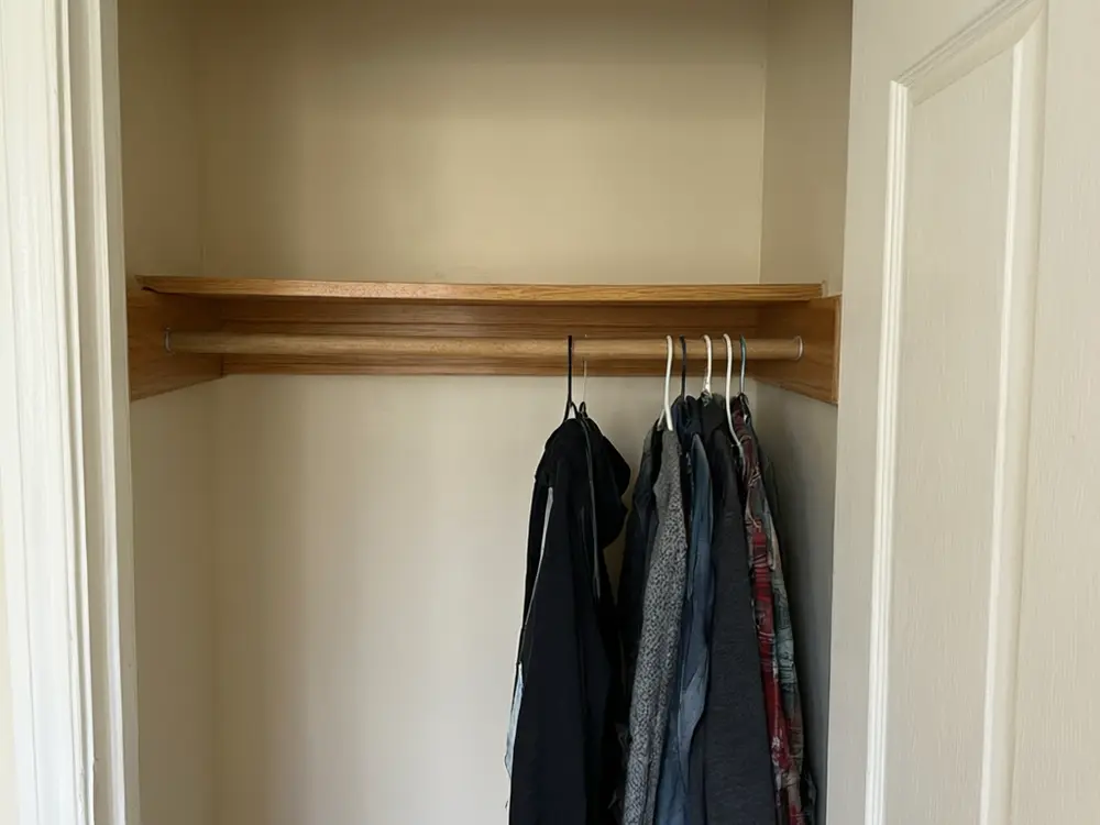 Closet visualizer result: a white walk-in closet with hanging rods, shelves and a drawer island before AI redesign