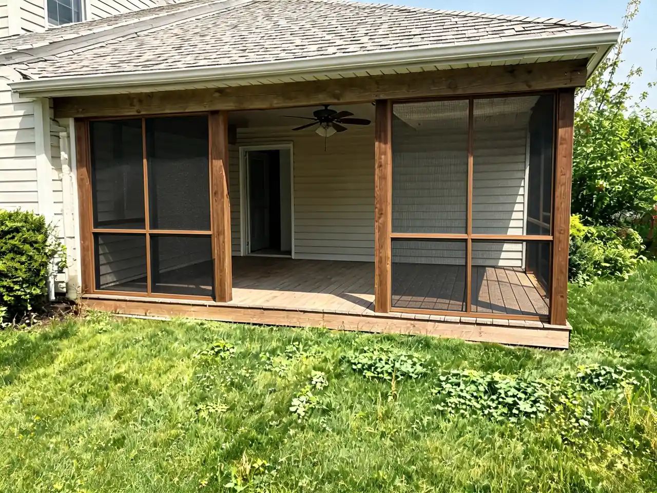 Porch visualizer result: open covered porch converted into a screened-in porch with stained wood framing after AI redesign