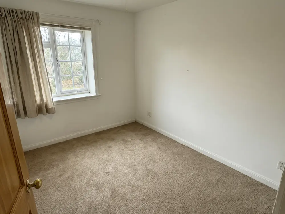 Nursery visualizer result: a calm neutral nursery with a white crib, rug and rocking chair before AI redesign