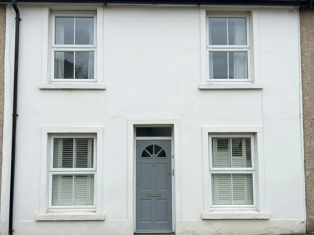 Shutter visualizer result: black board and batten shutters added to a white house before AI redesign